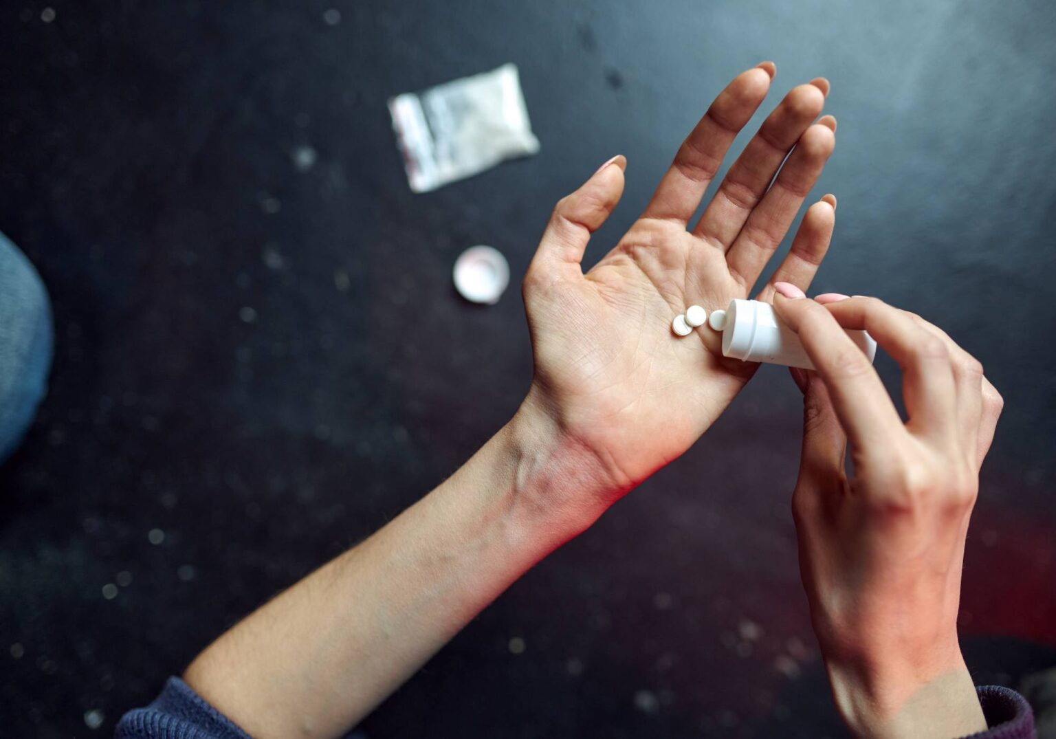 Close-up of hands holding pills from a bottle, evoking medication management